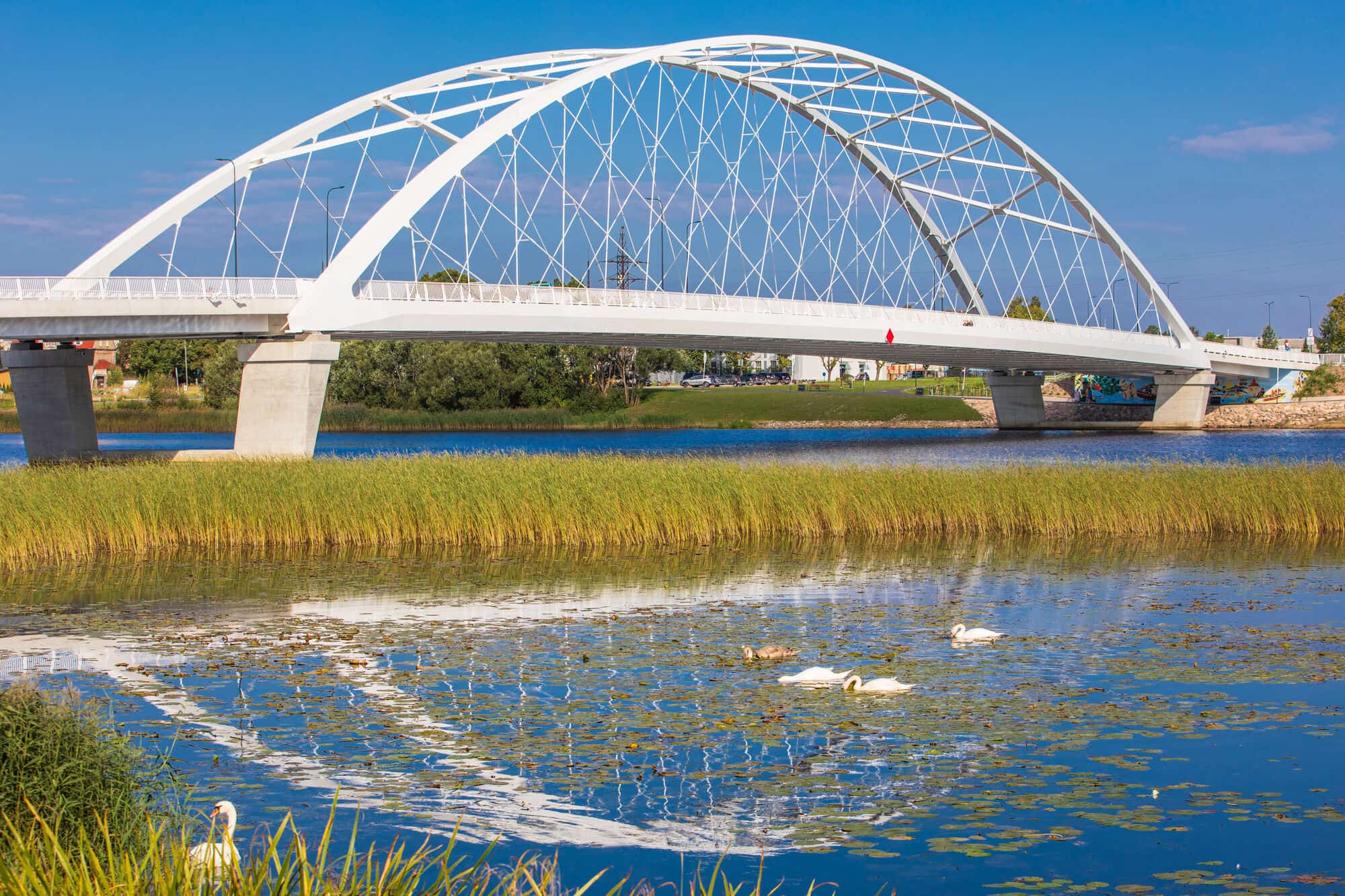The Pärnu bridge in Estonia, a white steel network arch over the river, hung on Daver tie bars
